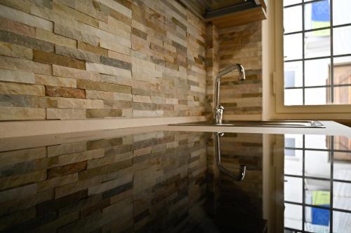 a bathroom with a sink and a brick wall at L'Erika in Città in Livorno