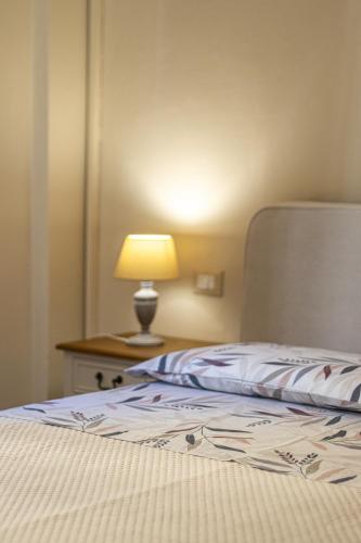 a bedroom with a bed with a lamp on a table at L'Erika in Città in Livorno