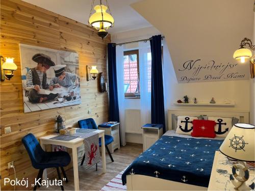 a bedroom with a bed and a table and chairs at Willa Klara in Jastarnia