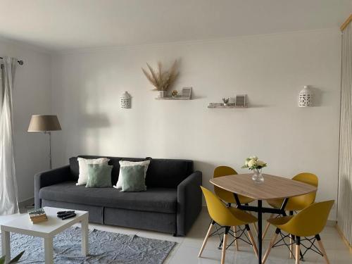 a living room with a couch and a table at Apartamento encantador a 100m da praia in Carvoeiro