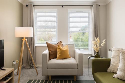 a living room with a chair and a window at Modern 2-Bedroom Apartments with Free Parking in Leamington Spa in Leamington Spa