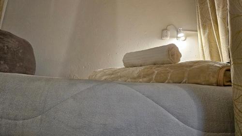 a bedroom with a bed with a rolled up sheet at Casa Samor La Candelaria in Bogotá