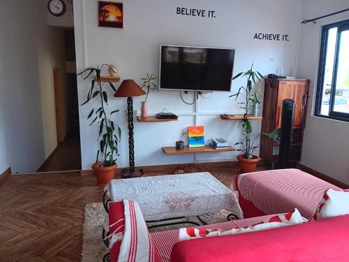 a living room with two couches and a flat screen tv at Fleur d'Epine in Trou dʼ Eau Douce