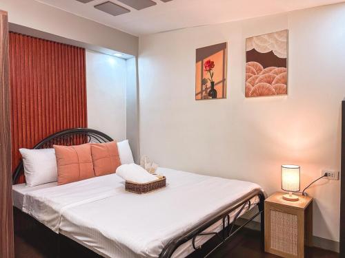 a bedroom with a bed with a lamp on a table at The Loft 2 in Cabanatuan