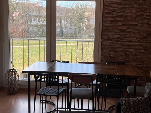 une table et des chaises dans une pièce avec une grande fenêtre dans l'établissement Suite de la Citadelle, à Belfort