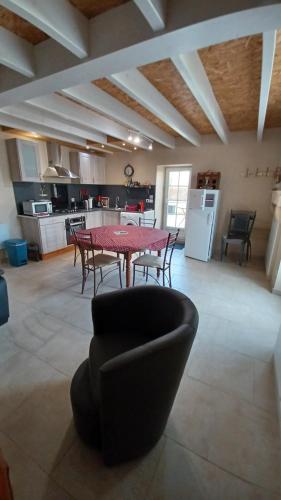 un salon avec une table et des chaises et une cuisine dans l'établissement Gîte Mimi, à Saint-Sulpice-de-Faleyrens