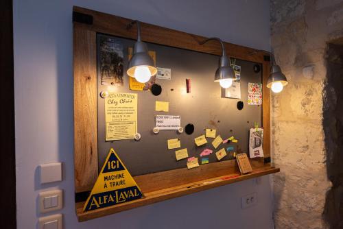 a bulletin board on a wall with signs on it at Gite Les 3M in Baugy