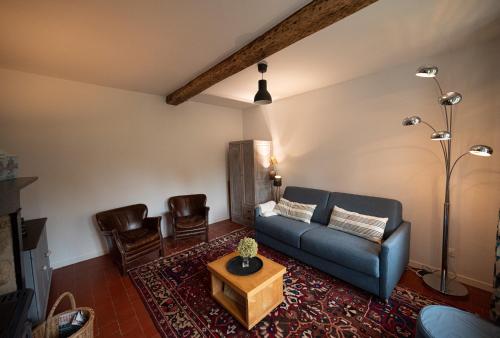 a living room with a blue couch and a table at Gite Les 3M in Baugy