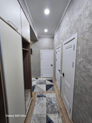 a hallway with two white doors and a stone wall at Golden house deluxe in Bukhara