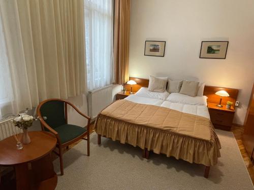 a hotel room with a bed and a chair at Ricsika Panzió in Tornyospálca