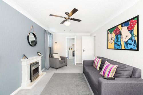 a living room with a gray couch and a ceiling fan at Modern 2-Bedroom Apartments with Free Parking in Leamington Spa in Leamington Spa