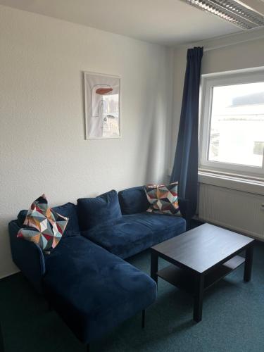 a living room with a blue couch and a table at BM Rooms - Bamberger Gemütlichkeit in Bamberg