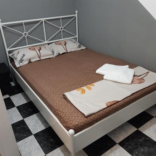 a bed with a metal frame and two pillows on it at B&B Duo Caffe in Bucharest