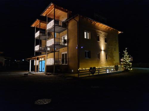 a building with a christmas tree in front of it at night at Steirermaxx Apartments in Gaal