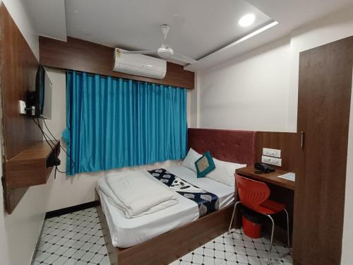 a small room with a small bed and a desk at Best Hotel in Mumbai