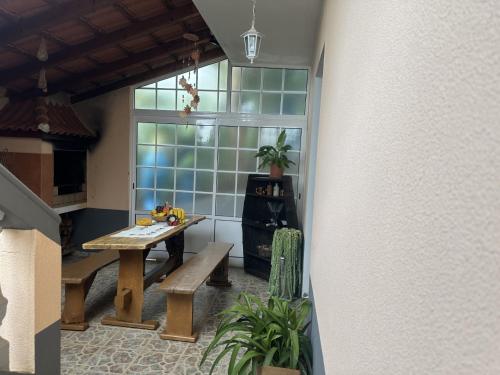Habitación con mesa, banco y ventana en Casa Mary Bela's, en Quinta do Almeida
