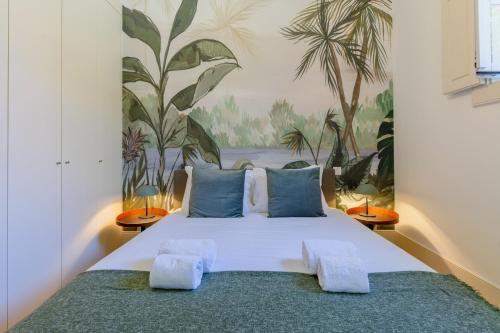 a bedroom with a large bed with blue pillows at Spacious apartment with patio at historic center in Porto