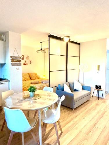 un salon avec une table, des chaises et un canapé dans l'établissement Appartement Cosy, à Montauban
