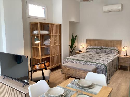 a bedroom with a bed and a tv and a table at Delicias Beach in Málaga