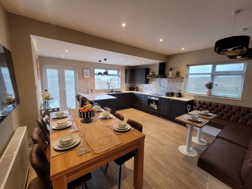 a dining room and kitchen with a wooden table and chairs at Tower Suites - HOT TUB sleeps 14 in Blackpool