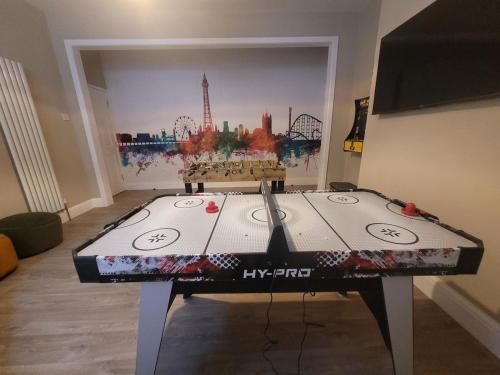 a table in a room with a painting on the wall at Tower Suites - HOT TUB sleeps 14 in Blackpool