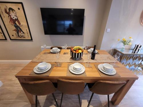 a wooden table with a bowl of fruit on it at Tower Suites - HOT TUB sleeps 14 in Blackpool