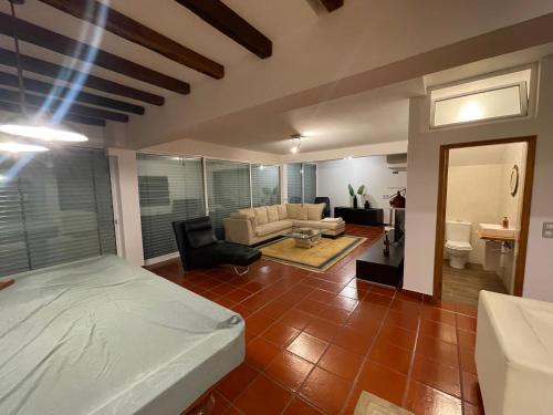 a bedroom with a bed and a living room at Palmeira`s Village in São Gonçalo