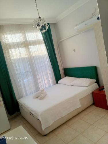 a bedroom with a white bed with a window at Duygu Otel Konaklama in Karatas