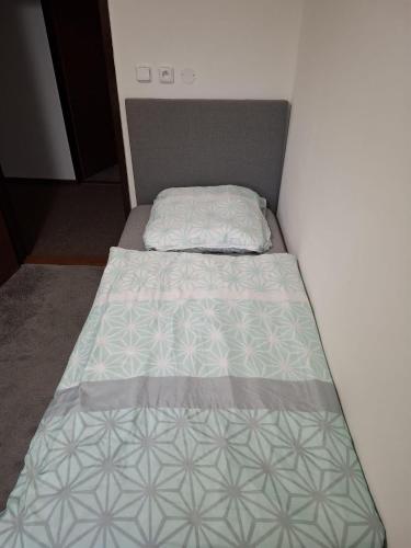 a small bed in a small room with a bedspread at Stará Pošta in Cheb