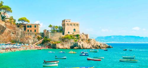a group of boats in the water in front of a castle at Casa Vacanza Gialu in Erchie