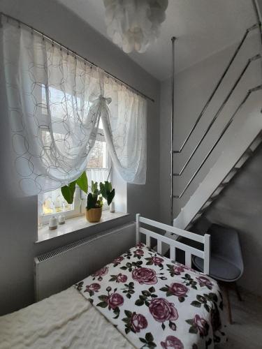 a bedroom with a bed and a window at Na Starówce in Lidzbark