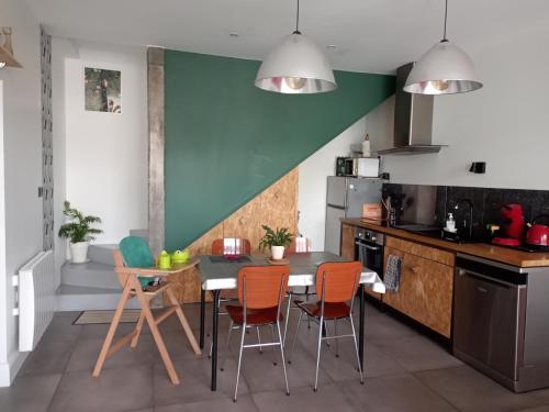 - une cuisine avec une table à manger et des chaises dans l'établissement Maison individuelle à Caen, à Caen