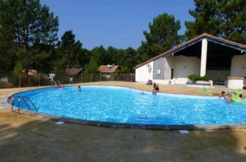 - une grande piscine avec des joueurs dans l'établissement Agréable petite maison près du golf et de la plage, à Moliets-et-Maa