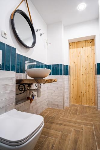 a bathroom with a toilet and a sink and a mirror at Guest apartment LOM in Ruse