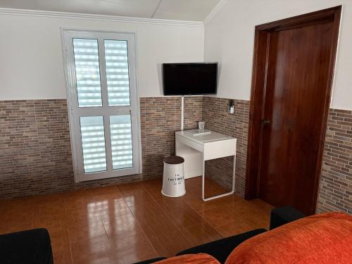 a room with a bed and a sink and a television at Casa da Ermida in Ponta Delgada