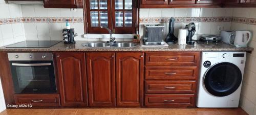 a kitchen with a sink and a washing machine at Casa da Ermida in Ponta Delgada