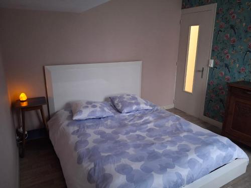 une chambre avec un lit avec une couette bleue et une fenêtre dans l'établissement Chambre lit double près de la Loire, à La Riotière