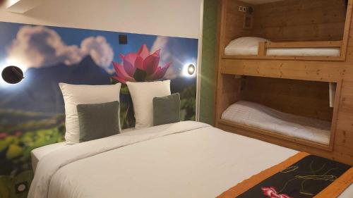 a room with a bed and two bunk beds at Le Lotus Blanc in Albertville