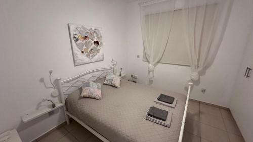 a white bedroom with a bed with two books on it at Luxury Apartment Paphos in Paphos