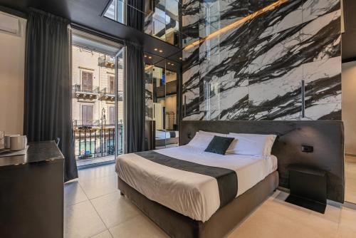 a bedroom with a bed with a painting on the wall at Amari120Suite&Spa in Palermo