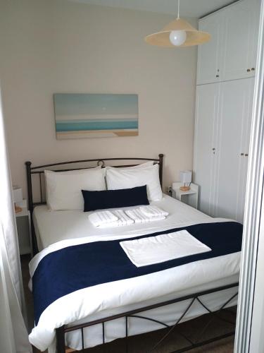 a bedroom with a large bed with blue and white sheets at Kea's Living Yard II in Korissia