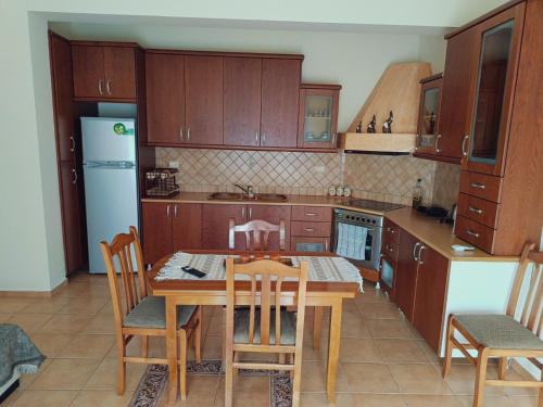 a kitchen with wooden cabinets and a table and chairs at La casa della Nonna in Piqeras