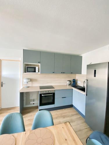 une cuisine avec une table et des chaises bleues dans l'établissement Chambre et salle de bain PRIVÉE dans Appartement PARTAGÉ avec toilettes partagés - Talence - Tram B - Ref R1, à Talence