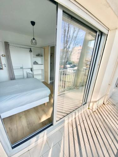 Cette chambre comprend un lit et une grande fenêtre. dans l'établissement Chambre et salle de bain PRIVÉE dans Appartement PARTAGÉ avec toilettes partagés - Talence - Tram B - Ref R1, à Talence