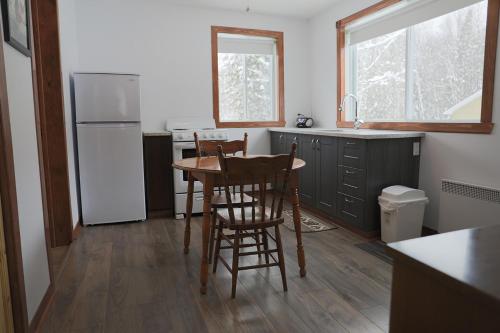 a kitchen with a table and chairs and a refrigerator at loft Gem in Duhamel