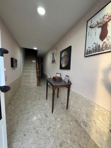 un pasillo con una mesa y escaleras en una casa en Pensión Portus Marini, en Portomarín