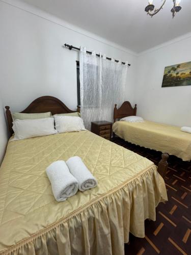 a bedroom with two beds with towels on them at House Mariona in Caminha