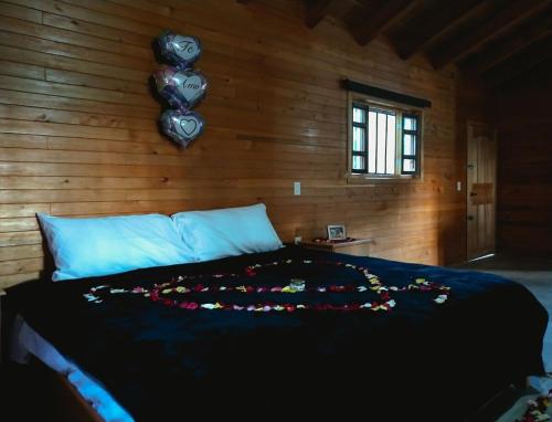 a bedroom with a bed with a bunch of flowers on it at Desconectate en Cabañitas Villaluxe San Cristobal de las Casas in San Cristóbal de Las Casas