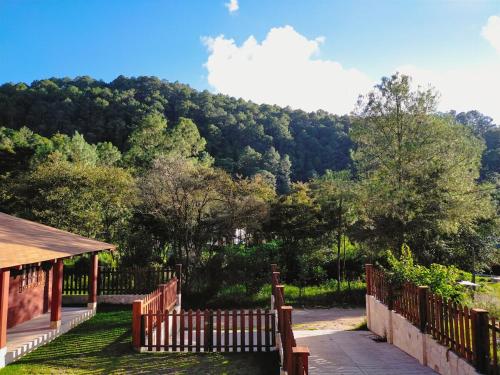 a wooden fence with a view of a mountain at Desconectate en Cabañitas Villaluxe San Cristobal de las Casas in San Cristóbal de Las Casas