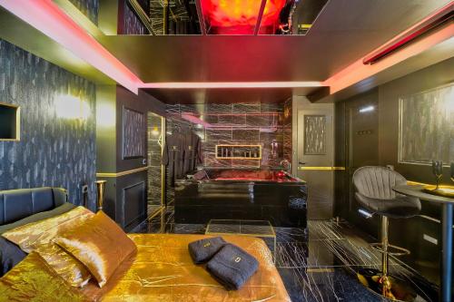 Cette chambre comprend un lit et une baignoire. dans l'établissement LA GOLDEN ROOM - Suite de Luxe avec Jacuzzi, à Mâcon